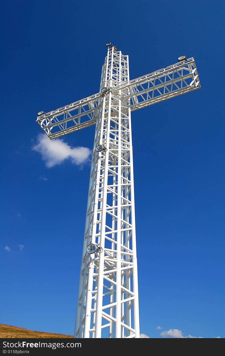 White steel cross on top of the mountain