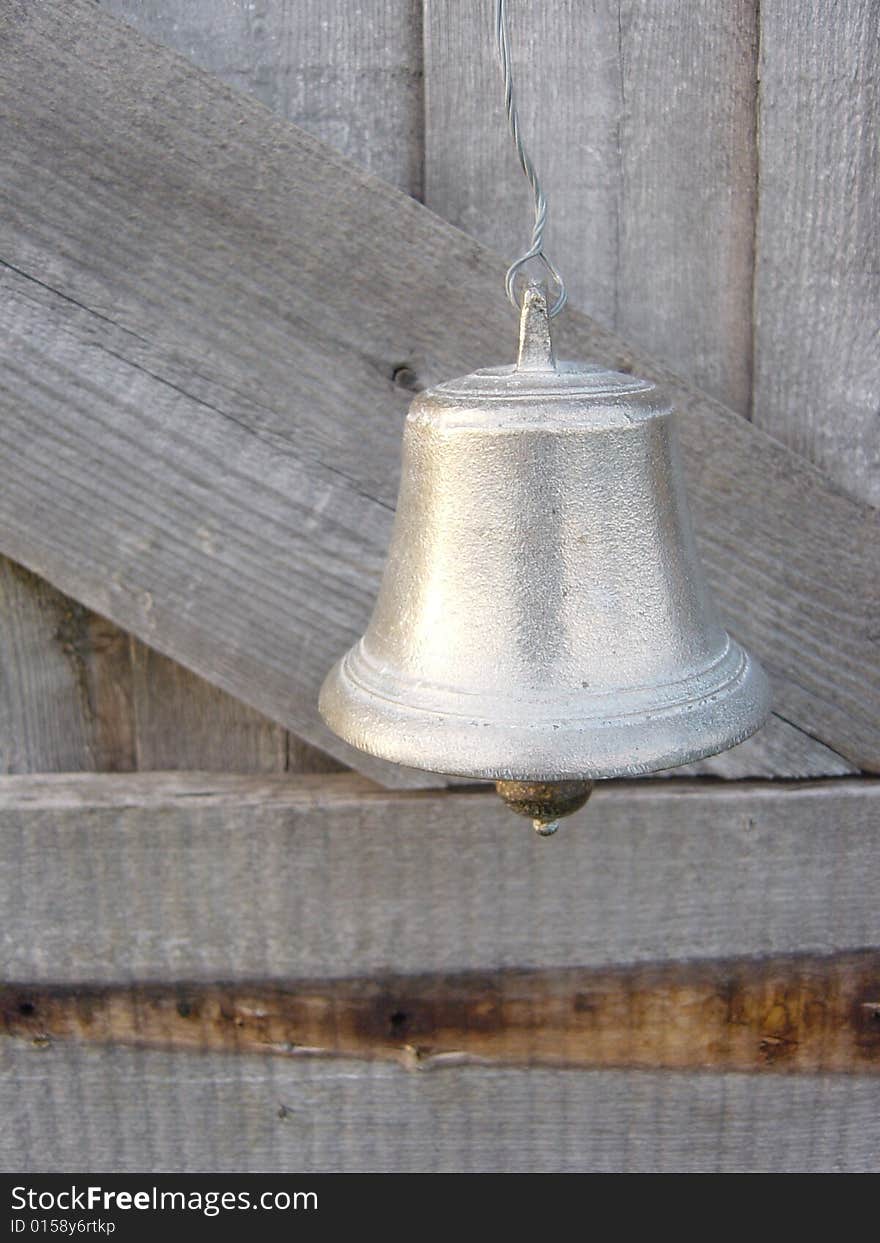 A small silver bell hanging on a door