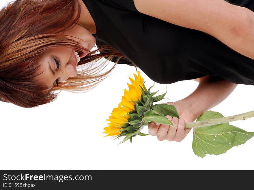 Young attractive woman is smiling to the sunflower. Studio shot on white background.