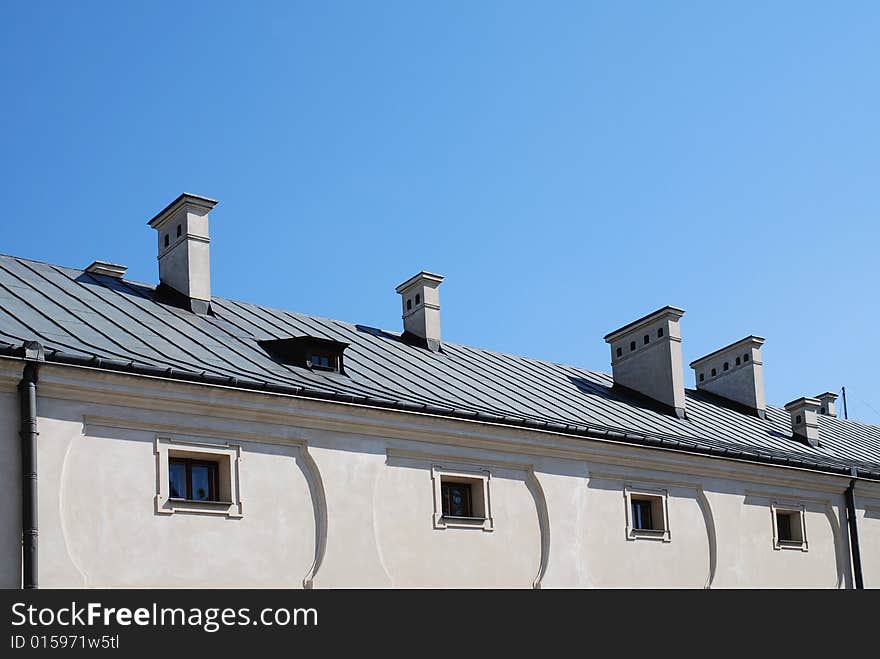 Old roof. chimney on the blue sky