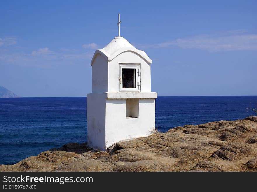 A white shrine in Sarti Beach overlooking the sea.