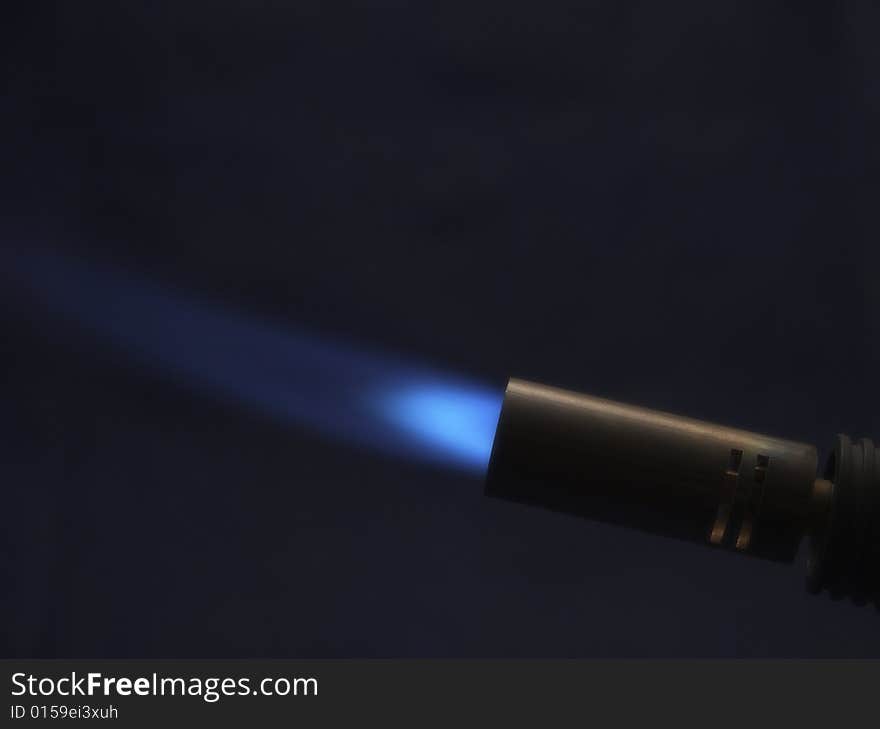 Blowlamp With Blew Flame on Dark Background