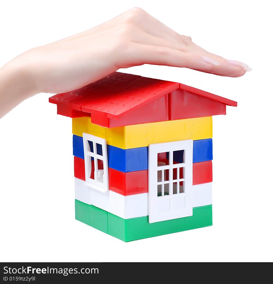 Hand of young woman protect toy colour plastic house with red roof. Hand of young woman protect toy colour plastic house with red roof