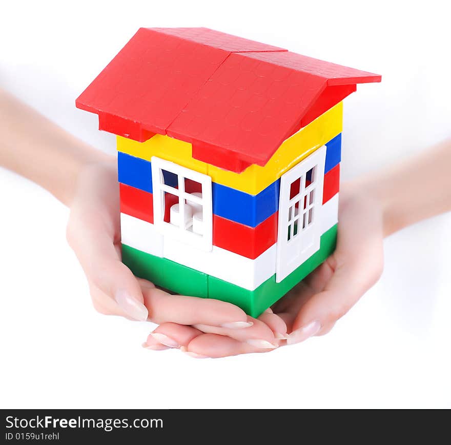 Toy colour plastic house with red roof in palms of young woman. Toy colour plastic house with red roof in palms of young woman