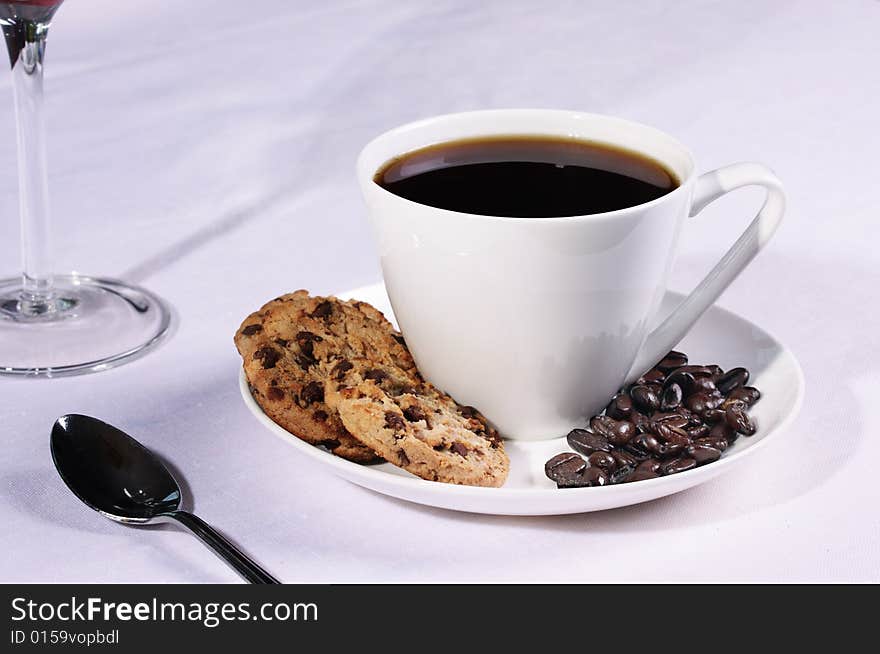 Coffee cup in a restaurant setting with biscuits and Coffee beans. Coffee cup in a restaurant setting with biscuits and Coffee beans