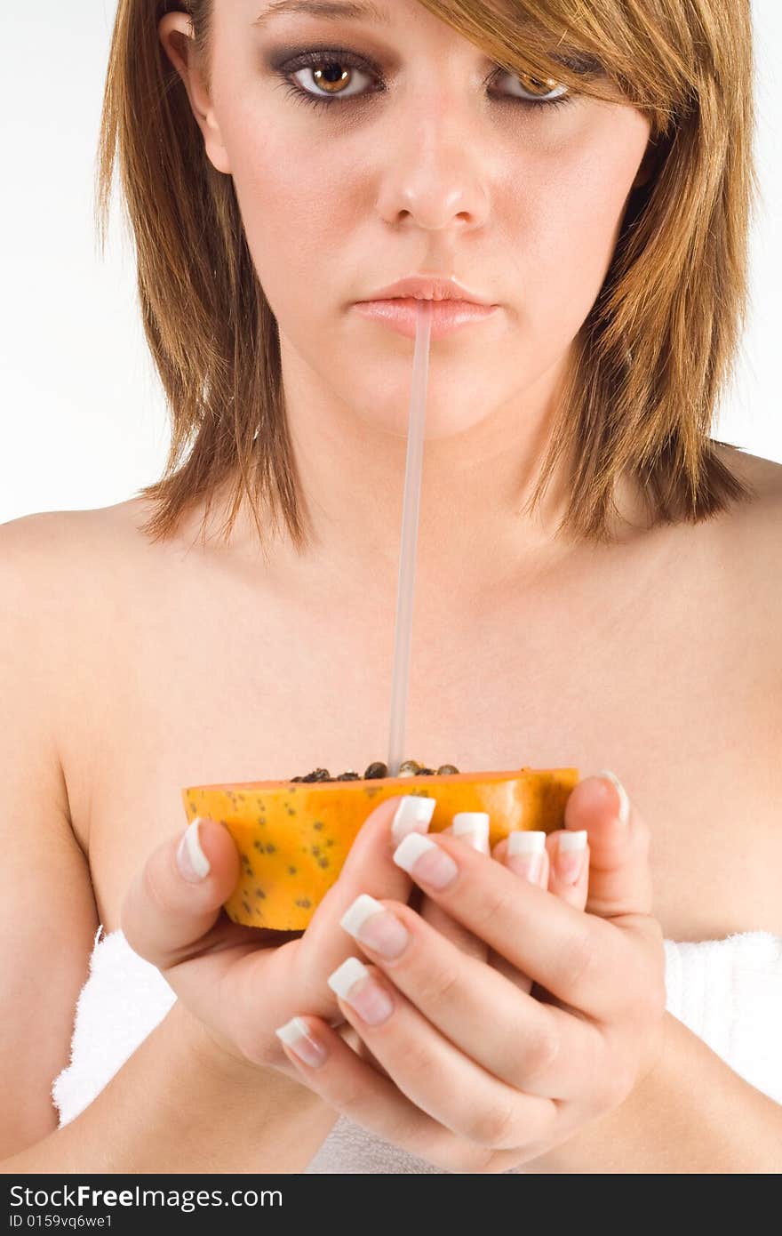 Girl drinking papaya through straw