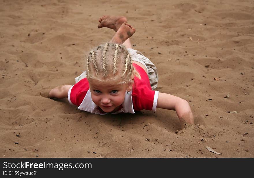 Little girl playing in sand dirtying her clothes and herself. Little girl playing in sand dirtying her clothes and herself