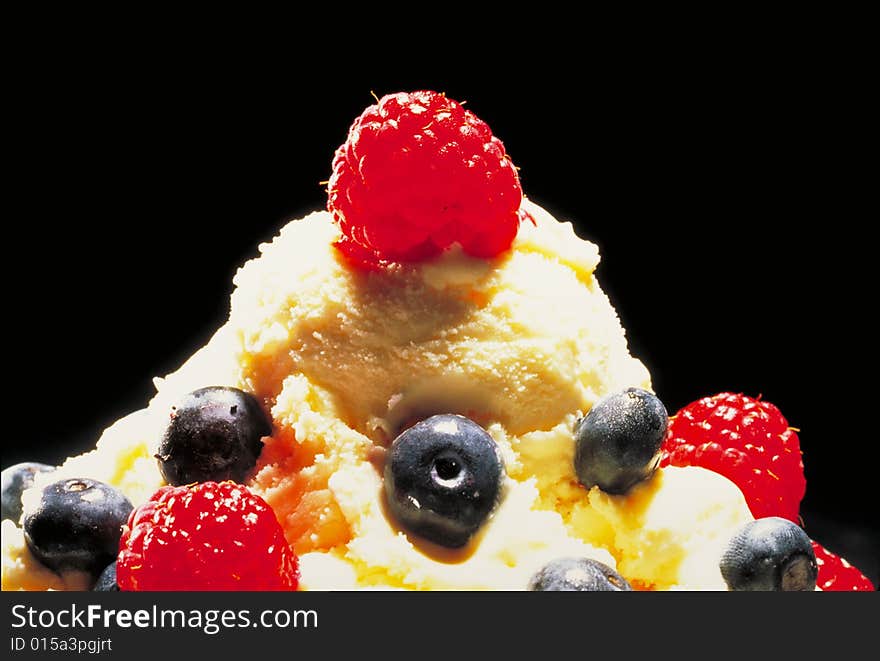 Vanilla ice cream with berries cherries and blueberries.