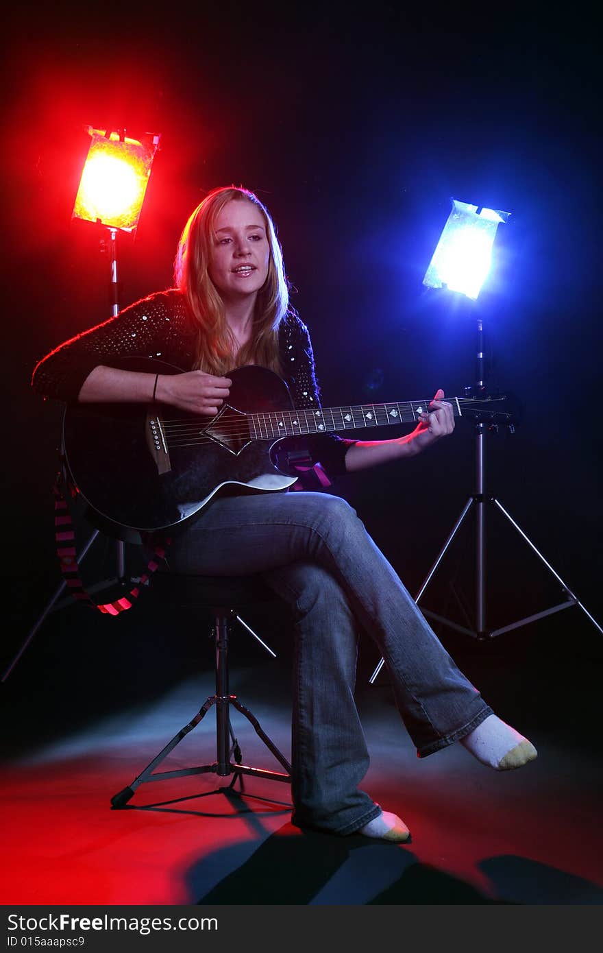 Woman on stage with red and blue concert lights