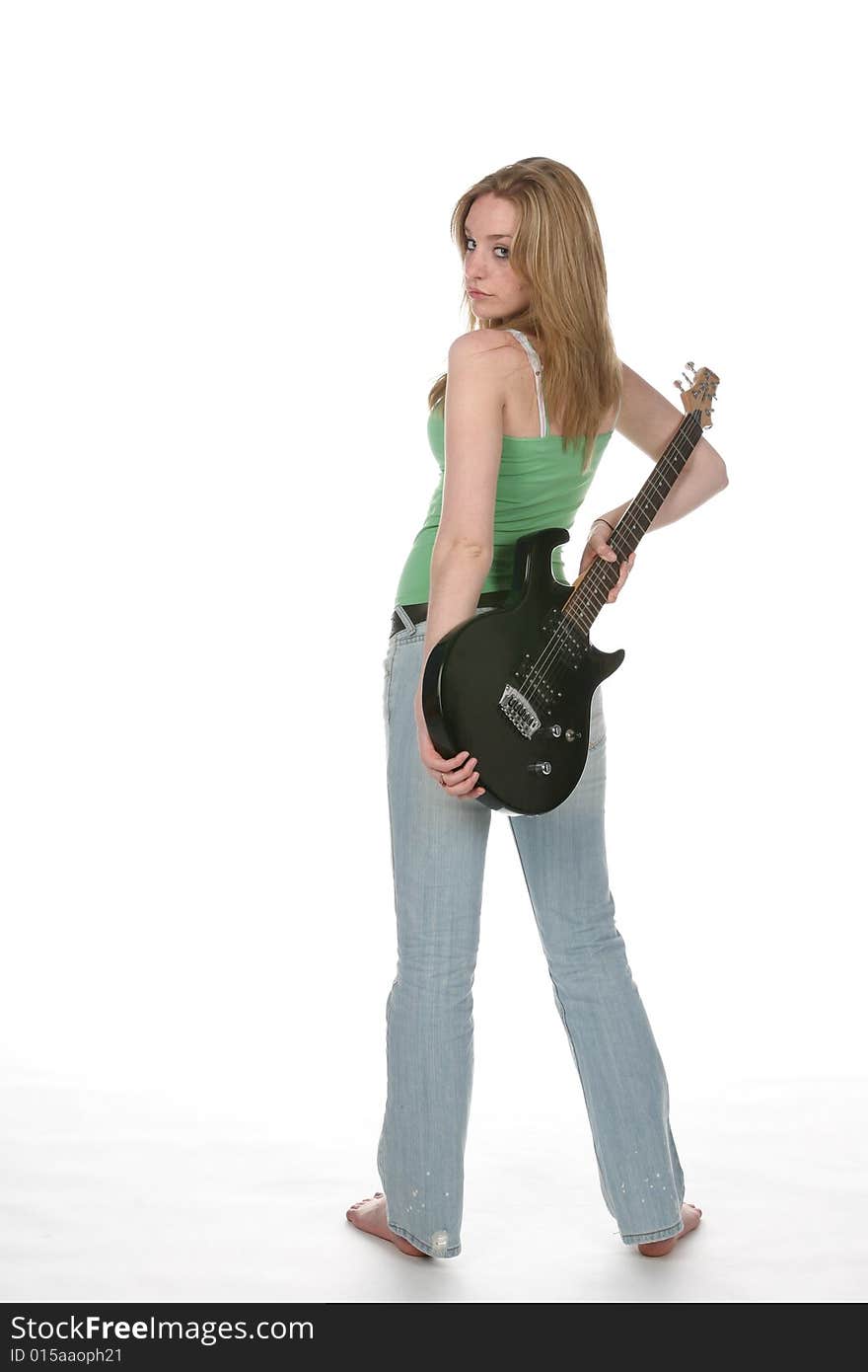 woman in tight jeans and green shirt with black electric guitar. woman in tight jeans and green shirt with black electric guitar