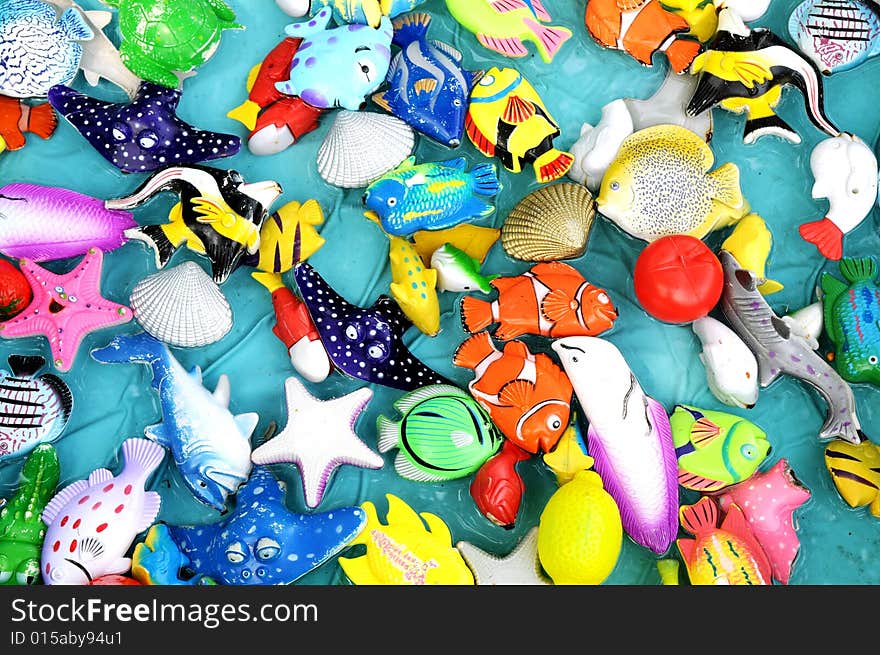 The colorful plastic toy sea animals floating in the water surface.