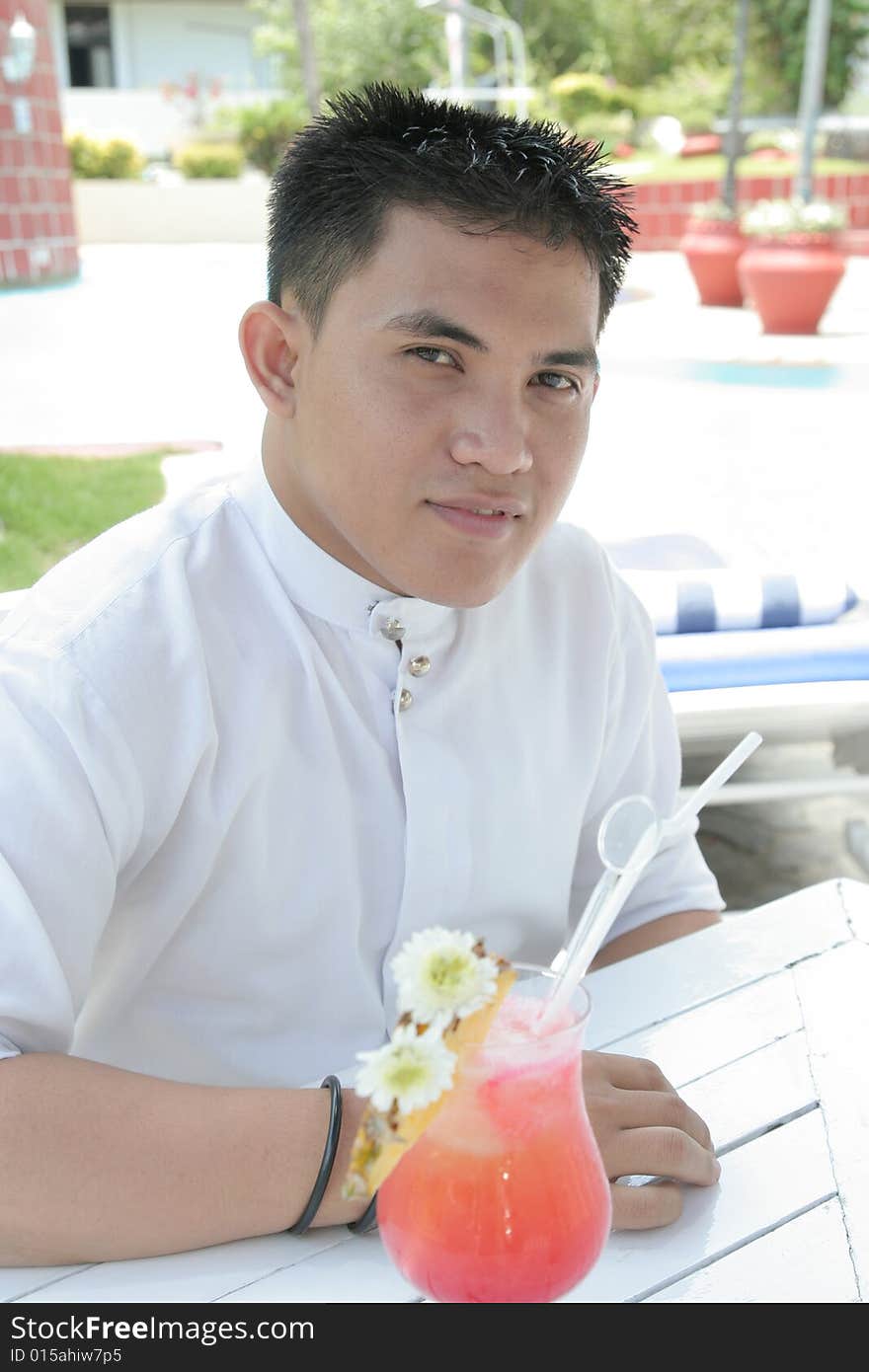 Man and Pineapple beverage at swimming pool. Man and Pineapple beverage at swimming pool