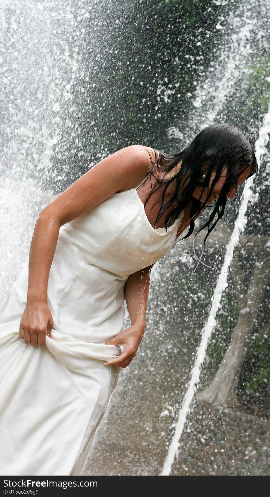 Bride playing under a water fountain. Bride playing under a water fountain.