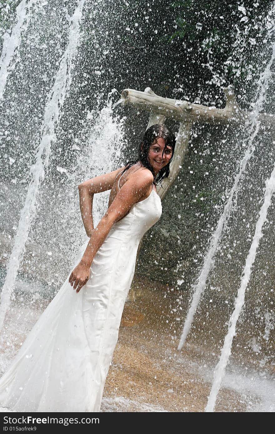 Bride playing under a water fountain. Bride playing under a water fountain.