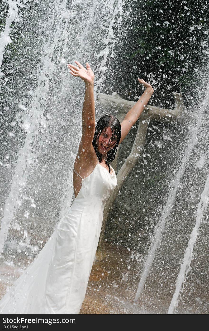 Bride playing under a water fountain. Bride playing under a water fountain.