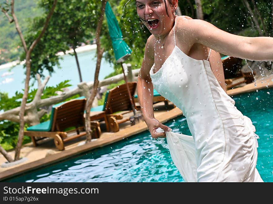 Tropical bride gets pushed into the pool on her wedding day. Trash the dress trend.