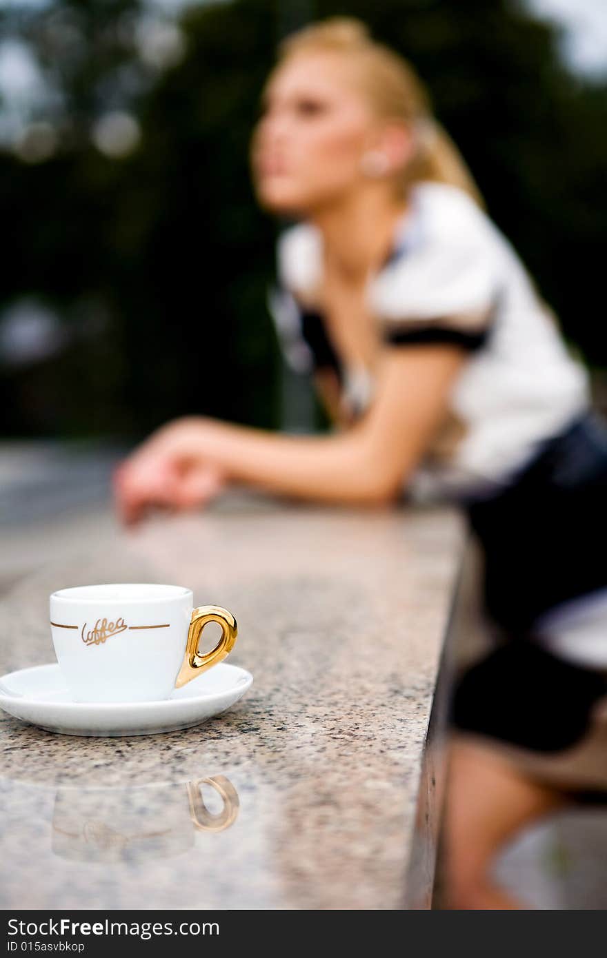 Blond lovely young woman drinking coffee outside. Blond lovely young woman drinking coffee outside