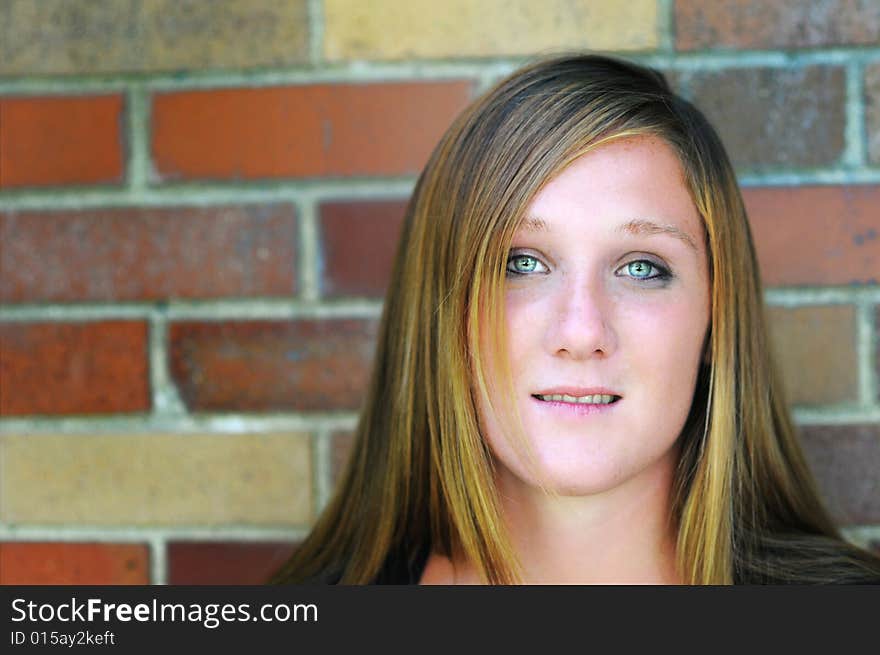 A green eyed woman standing in front of a wall. A green eyed woman standing in front of a wall