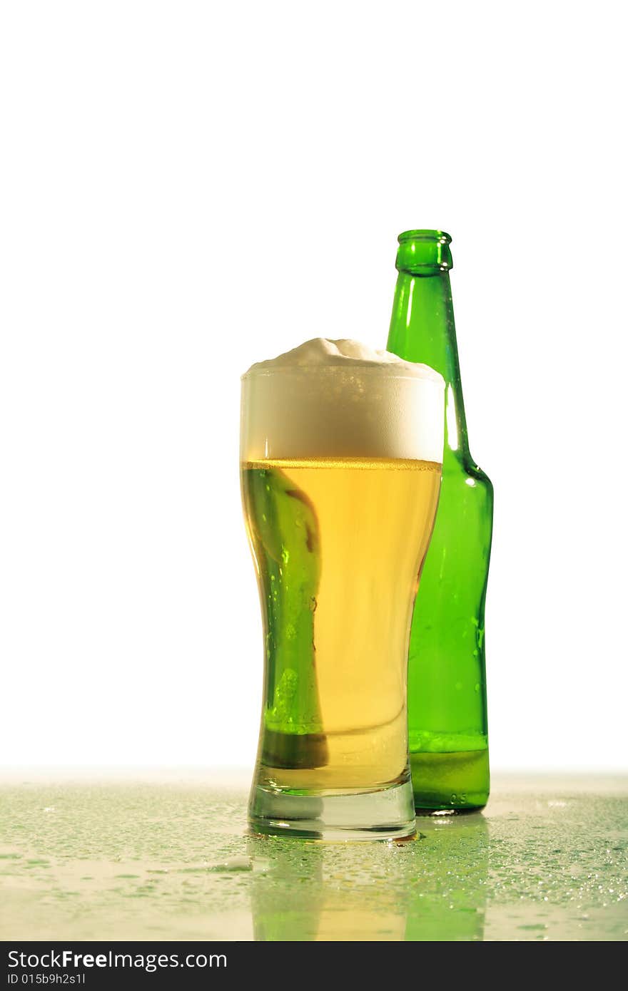 Glass of light beer and green bottle standing on white background. Glass of light beer and green bottle standing on white background