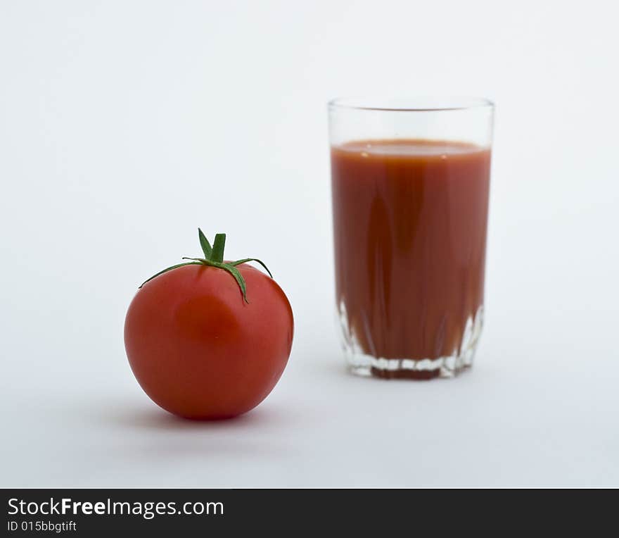 Fresh tomato and glass of juice on white background. Fresh tomato and glass of juice on white background