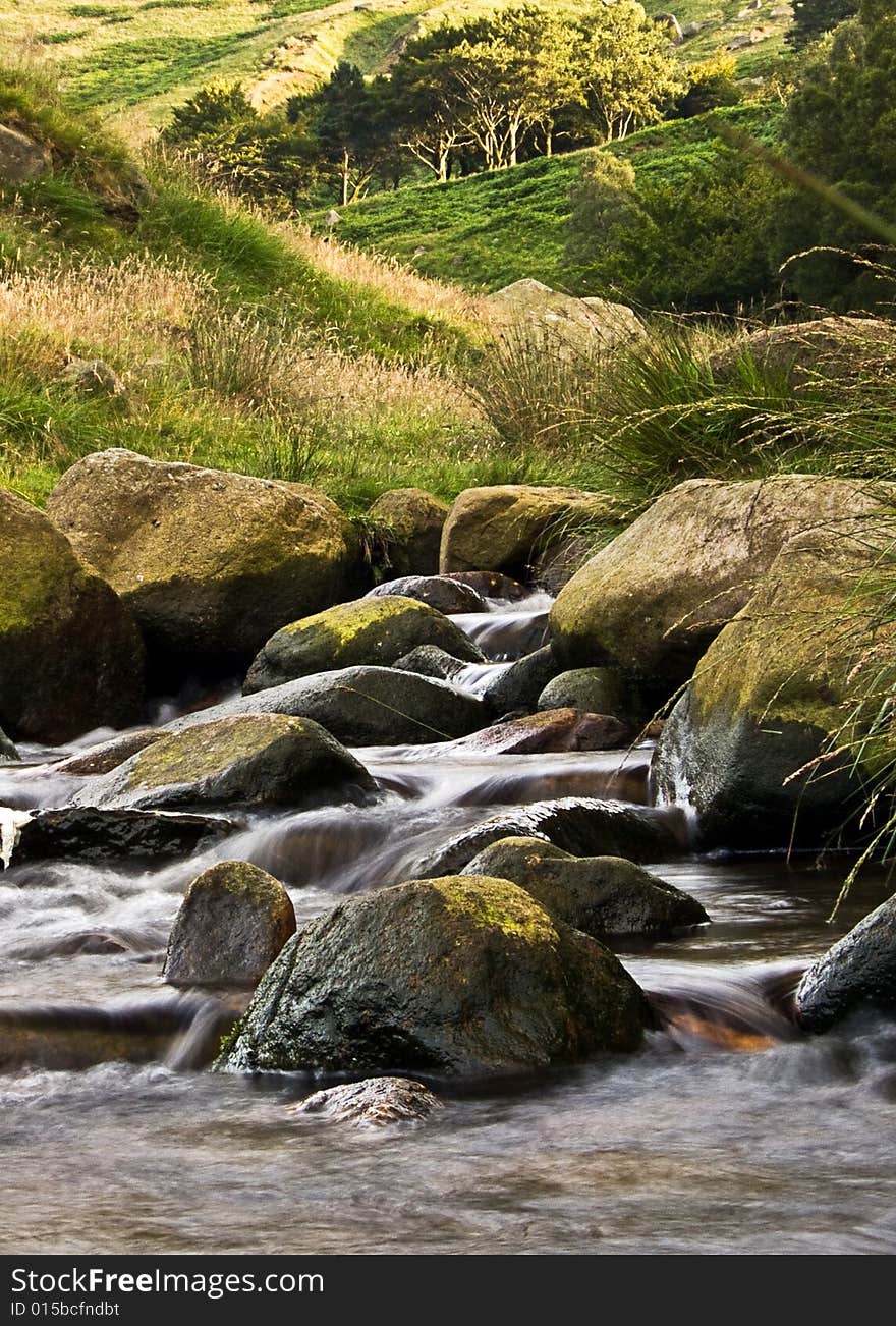 A stream flowing over some rocks. slow shutter speed showing some movement in the water. A stream flowing over some rocks. slow shutter speed showing some movement in the water.