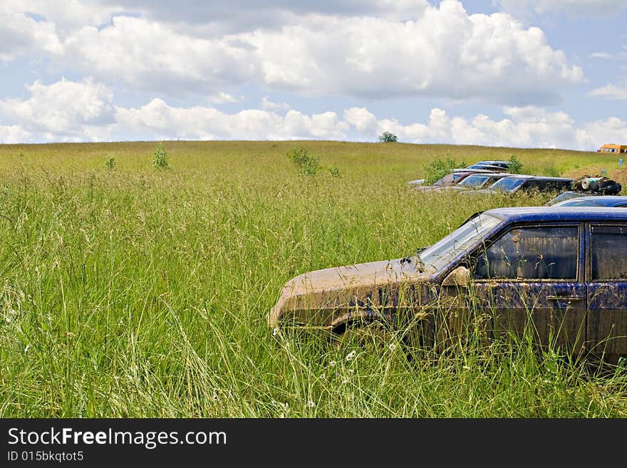 A dirty car standing in a green field. A dirty car standing in a green field