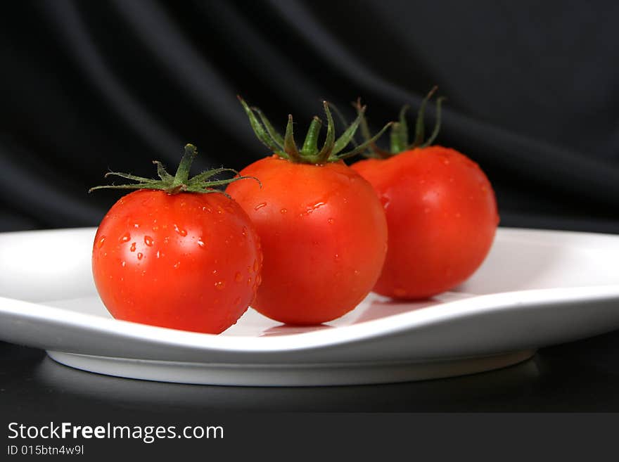 Fresh red tomatoes on white plate. Fresh red tomatoes on white plate