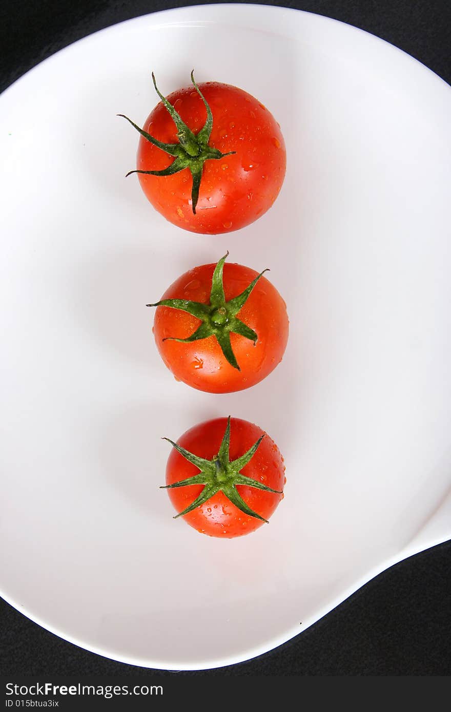 Fresh red tomatoes on white plate