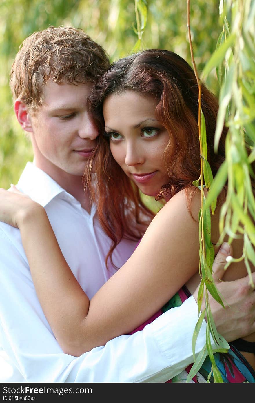 Cute young couple under green willow. Cute young couple under green willow