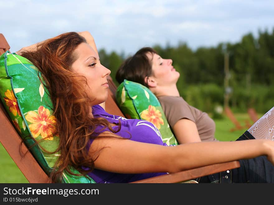 Two young girls relaxing outdoors. Two young girls relaxing outdoors