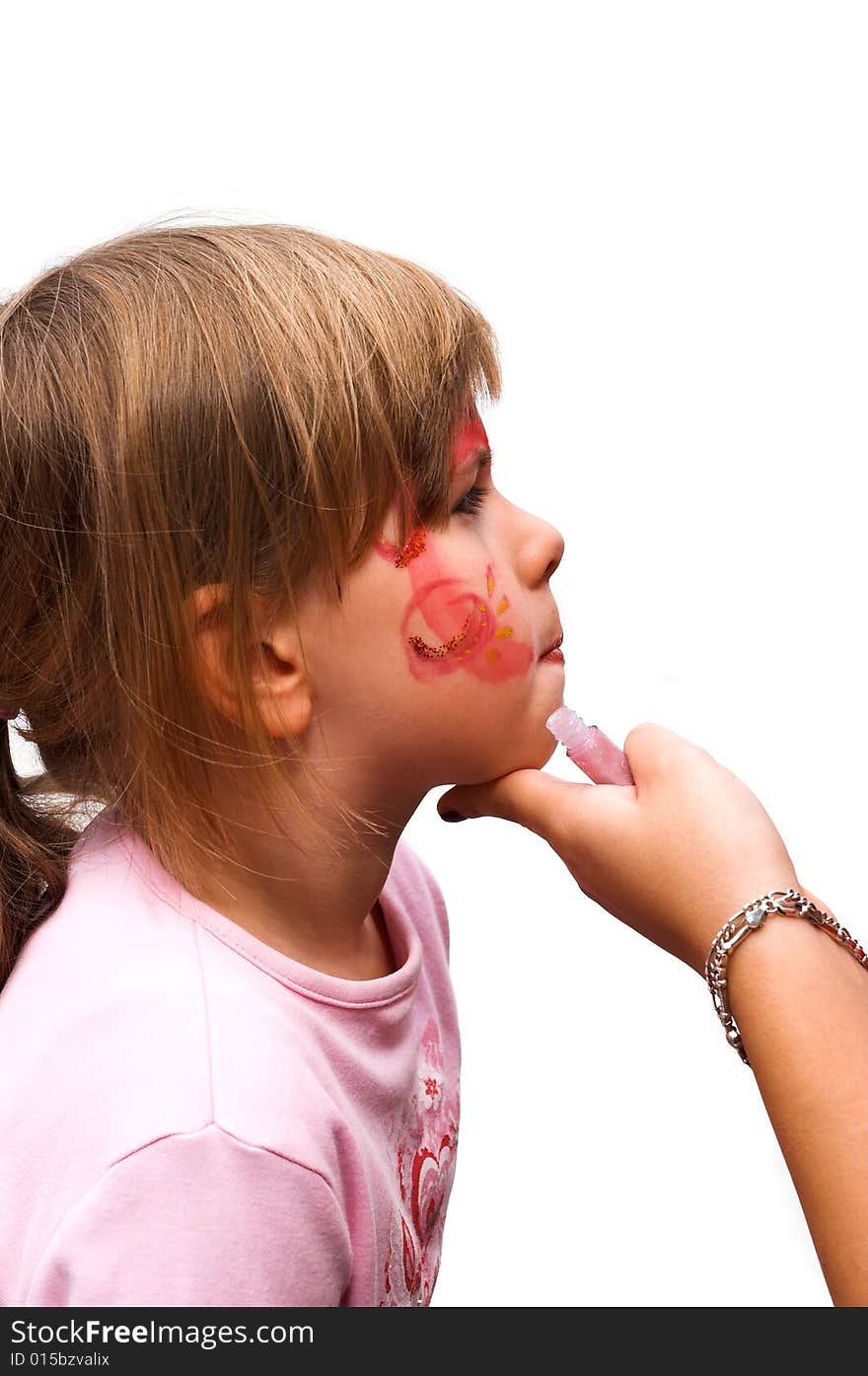 A little-girl is getting her face-painting for a street carnival. A little-girl is getting her face-painting for a street carnival