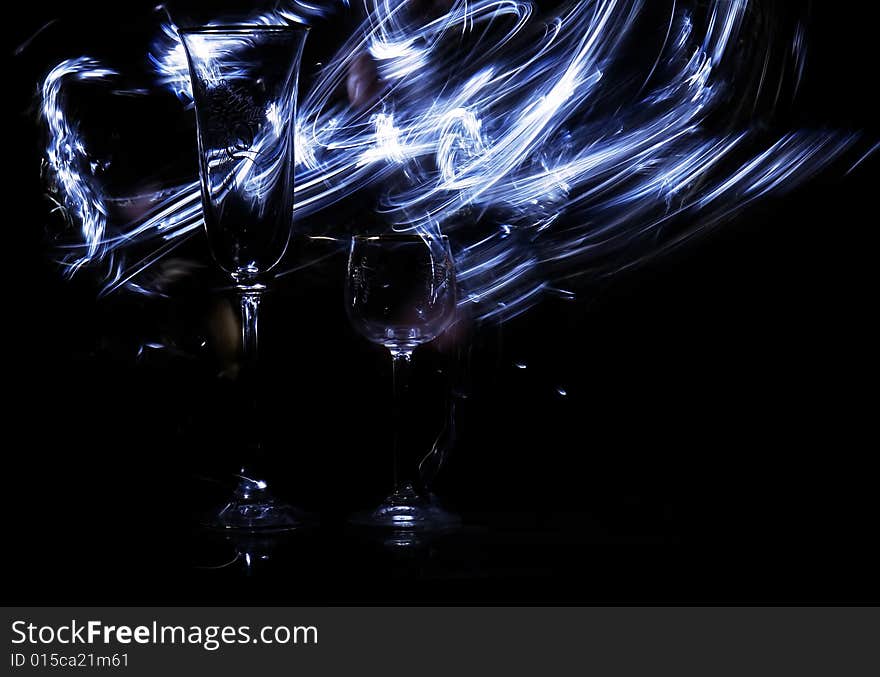 Two glasses in the black background with flash. Two glasses in the black background with flash