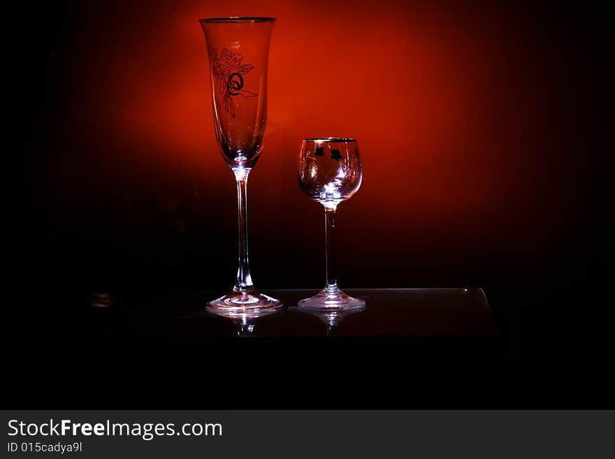 Two glasses in the black background with flash. Two glasses in the black background with flash