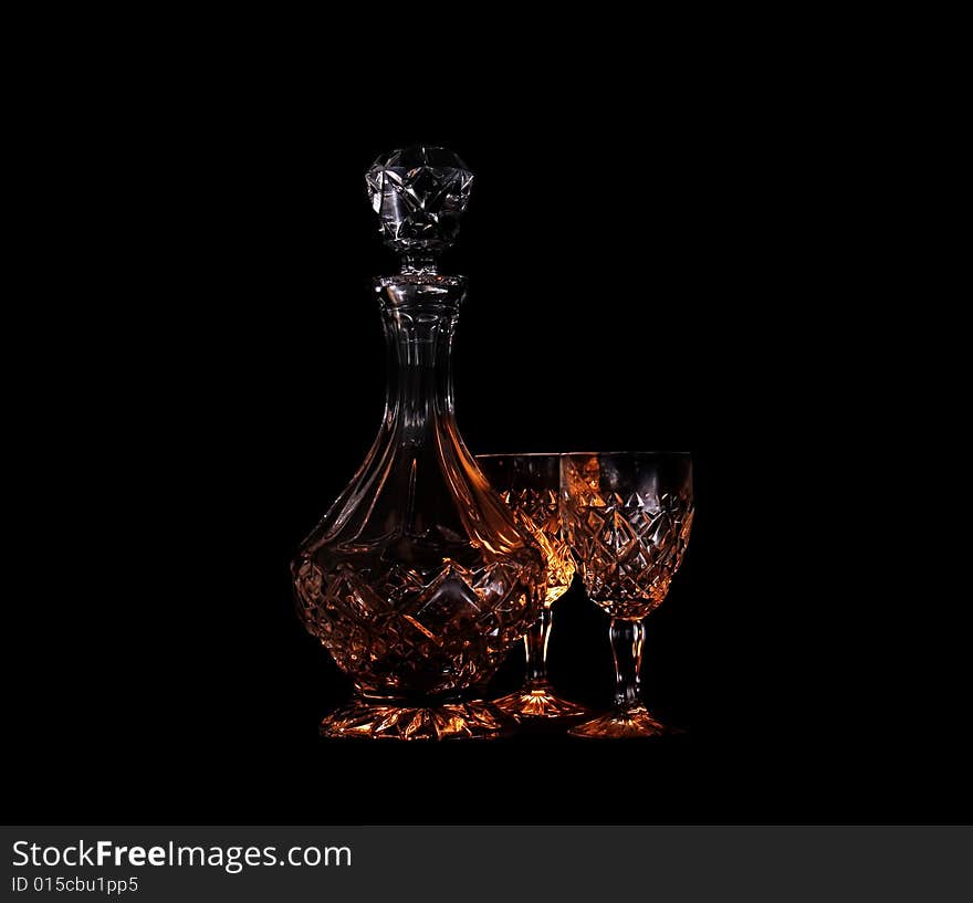 Decanter and two glasses in the black background with flash. Decanter and two glasses in the black background with flash