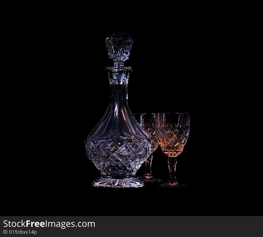 Decanter and two glasses in the black background with flash. Decanter and two glasses in the black background with flash