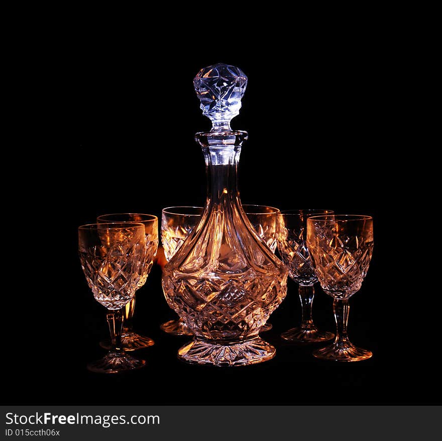 Decanter and two glasses in the black background with flash. Decanter and two glasses in the black background with flash