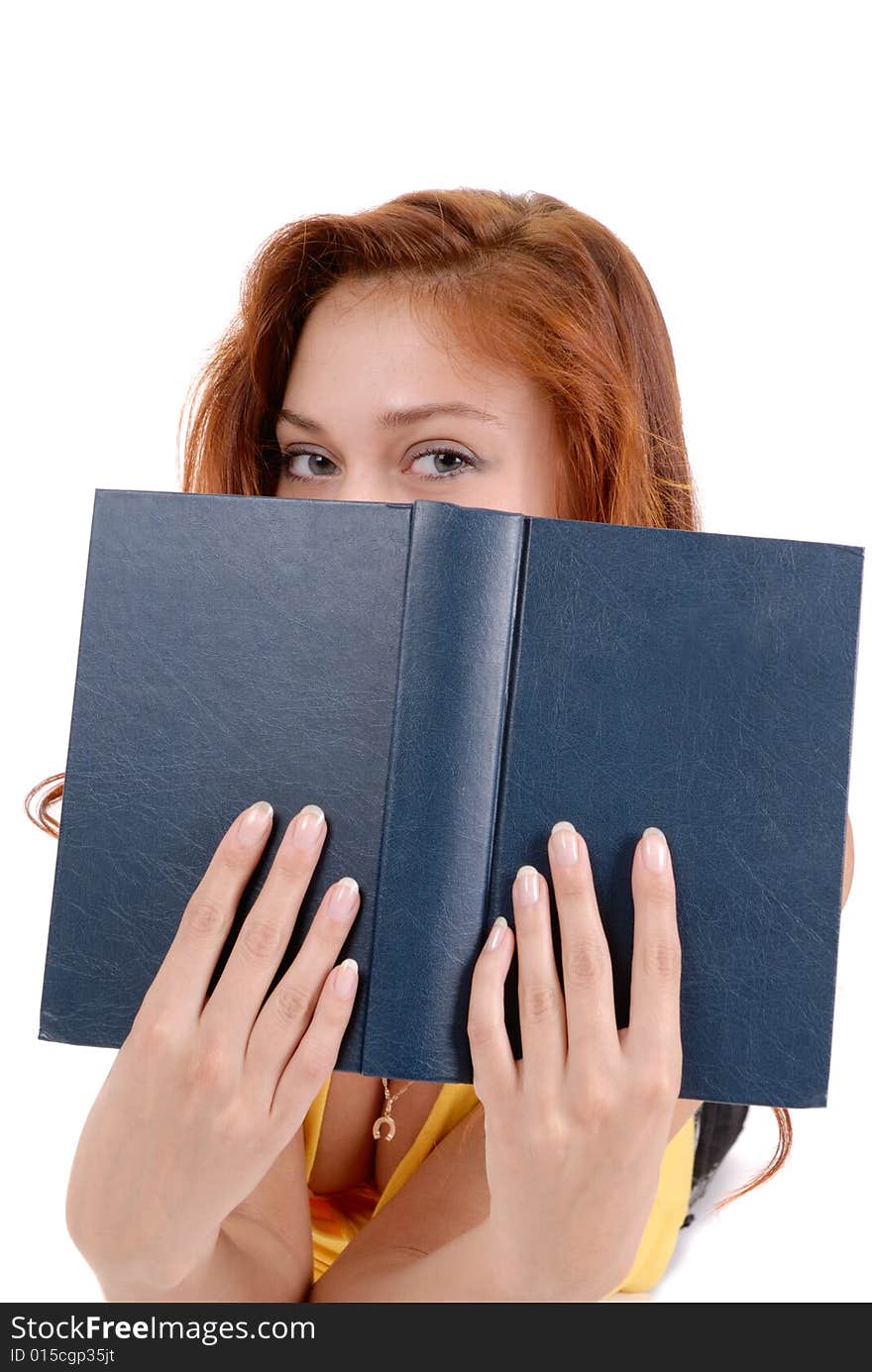 Portrait of a young student peeping from a book.