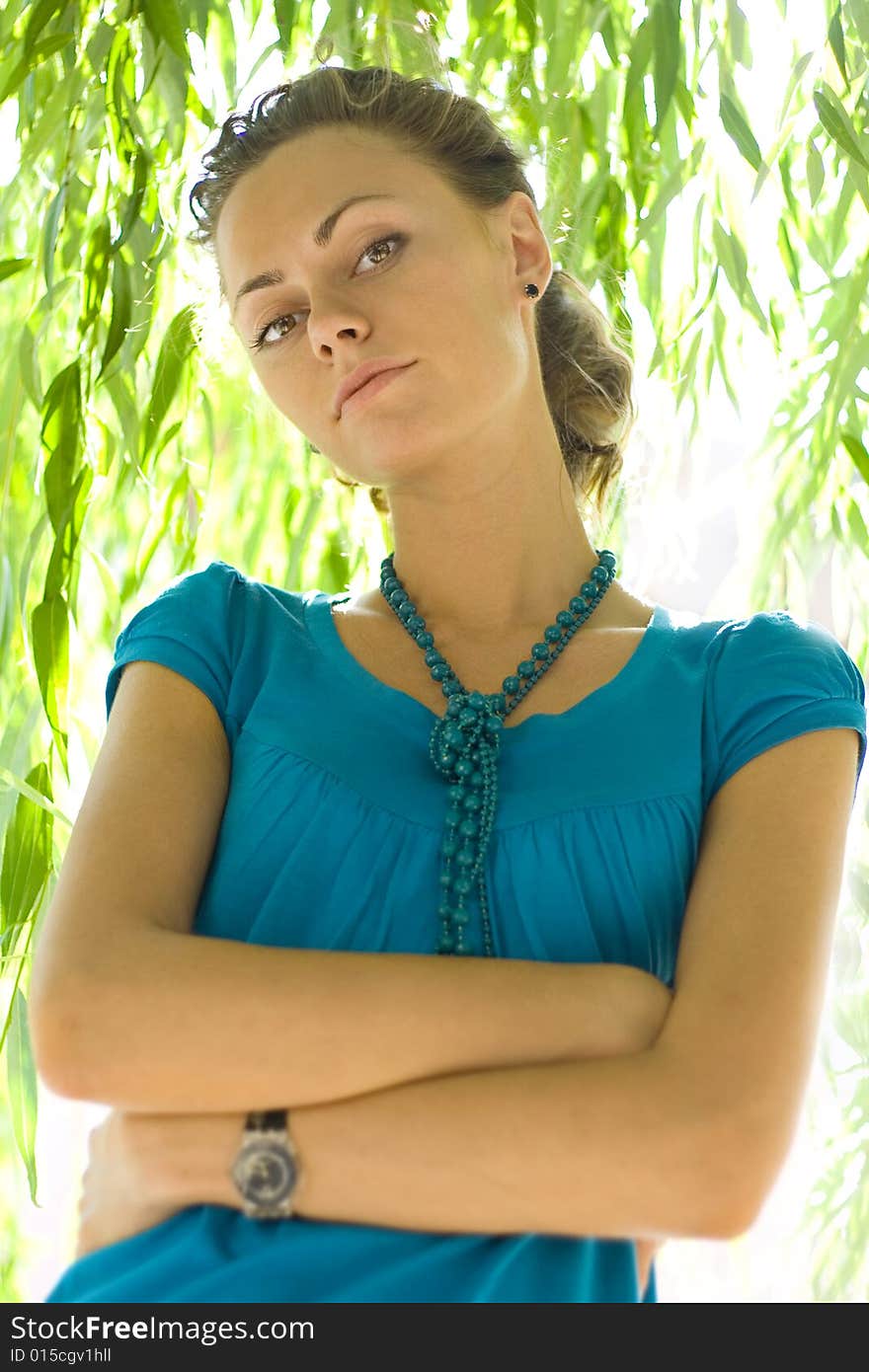 Beautiful woman with blue beads near willow. Beautiful woman with blue beads near willow