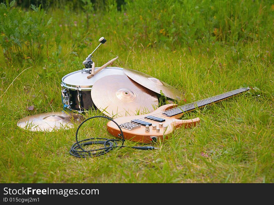 Musical instruments, guitar, drum, plates on grass