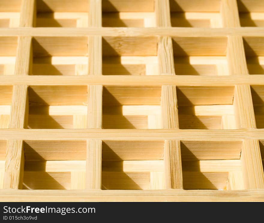 Two wooden grids overlaid on each other creating a 3D waffle pattern