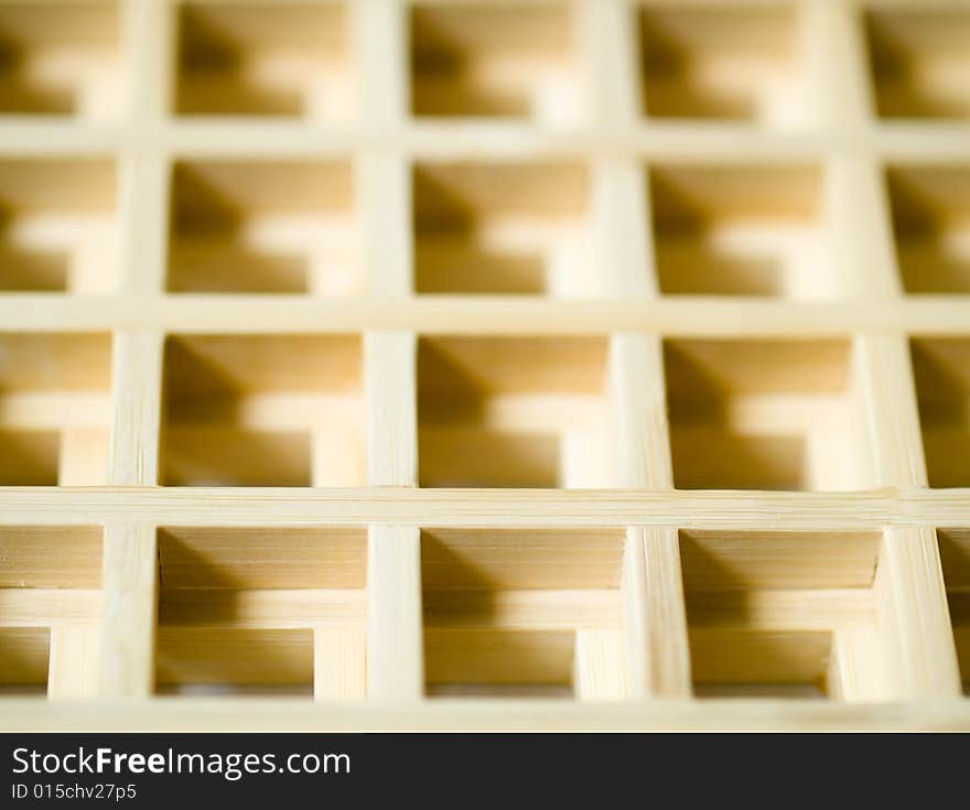 Two wooden grids overlaid on each other creating a 3D waffle pattern