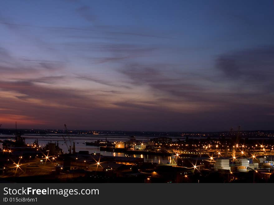 A view of Portsmouth Dock Yard at night with motor way light trails