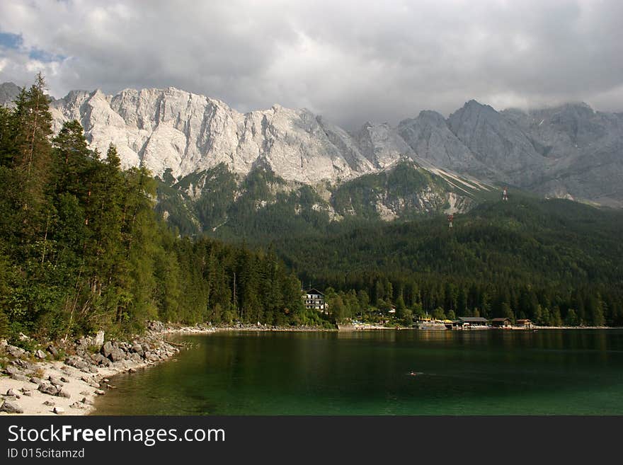 The summits of the Zugspitze massive(right, 2963m) and the Waxensteine (left, 2277m) in the german Alps near Garmisch-Partenkirchen. In the foreground the beautiful lake Eibsee.