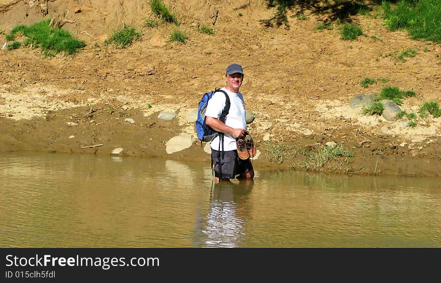 Hiker crosses a mountain river