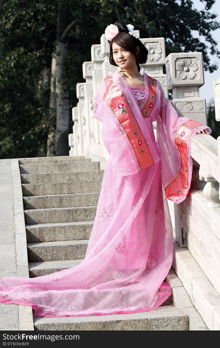 A girl in Chinese ancient dress. She is standing on the ancient bridge.She is so beautiful. A girl in Chinese ancient dress. She is standing on the ancient bridge.She is so beautiful.