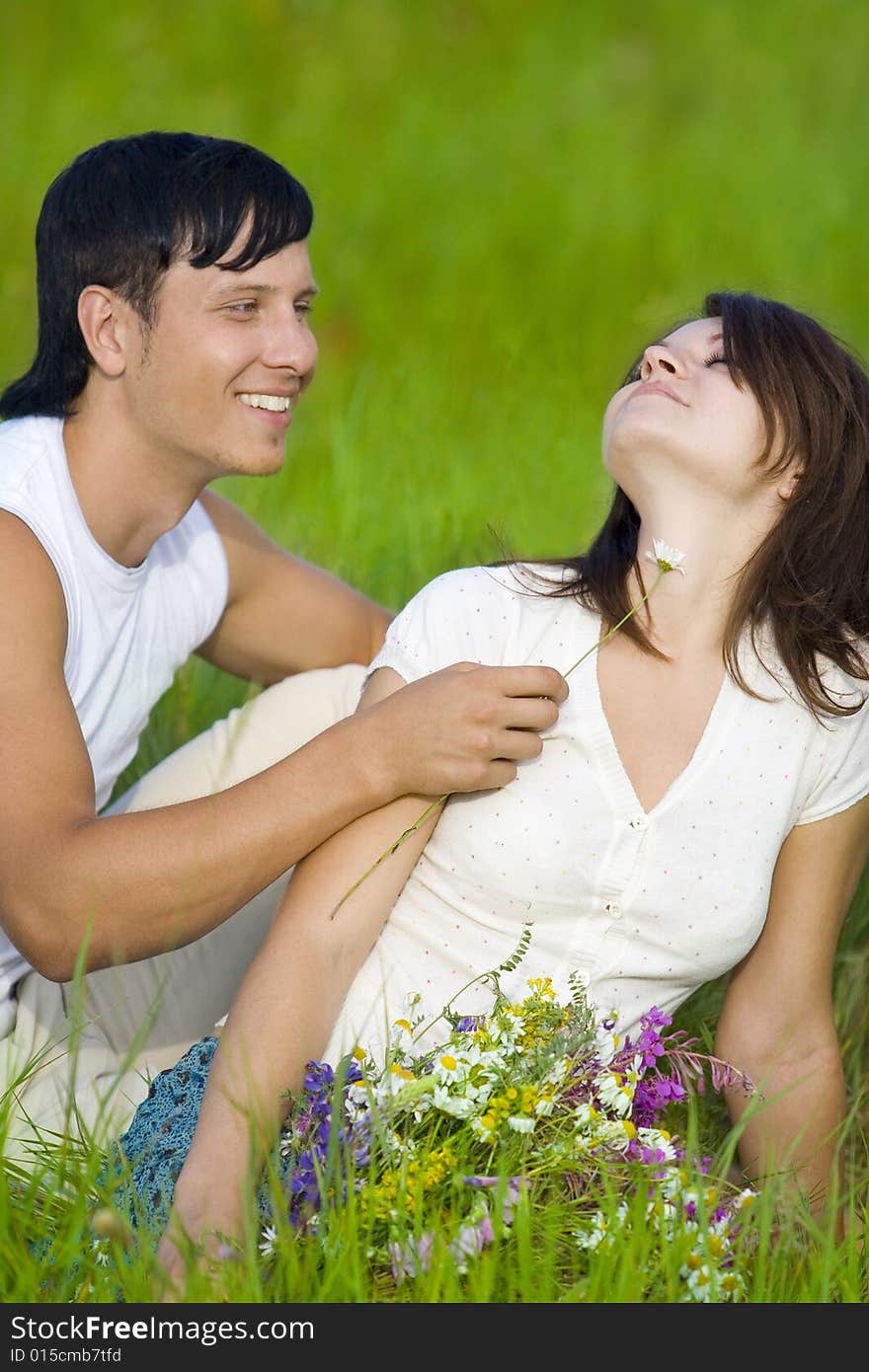 Man flirting with woman in field. Man flirting with woman in field