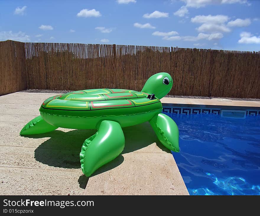 Green inflatable turtle near the swimming-pool. Green inflatable turtle near the swimming-pool