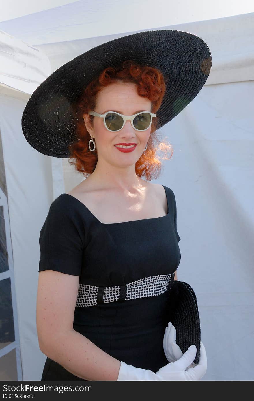 Glamorous fifties girl in vintage costume & sunglasses at Goodwood Revival event, UK. Glamorous fifties girl in vintage costume & sunglasses at Goodwood Revival event, UK