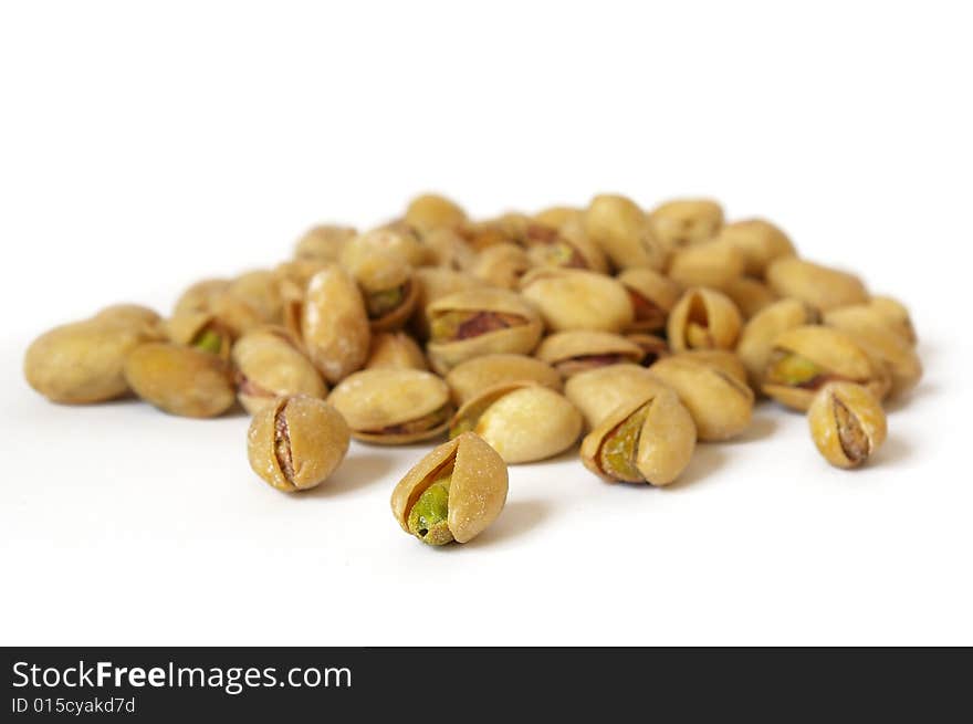 Heap of salty pistachios isolated. Soft focus