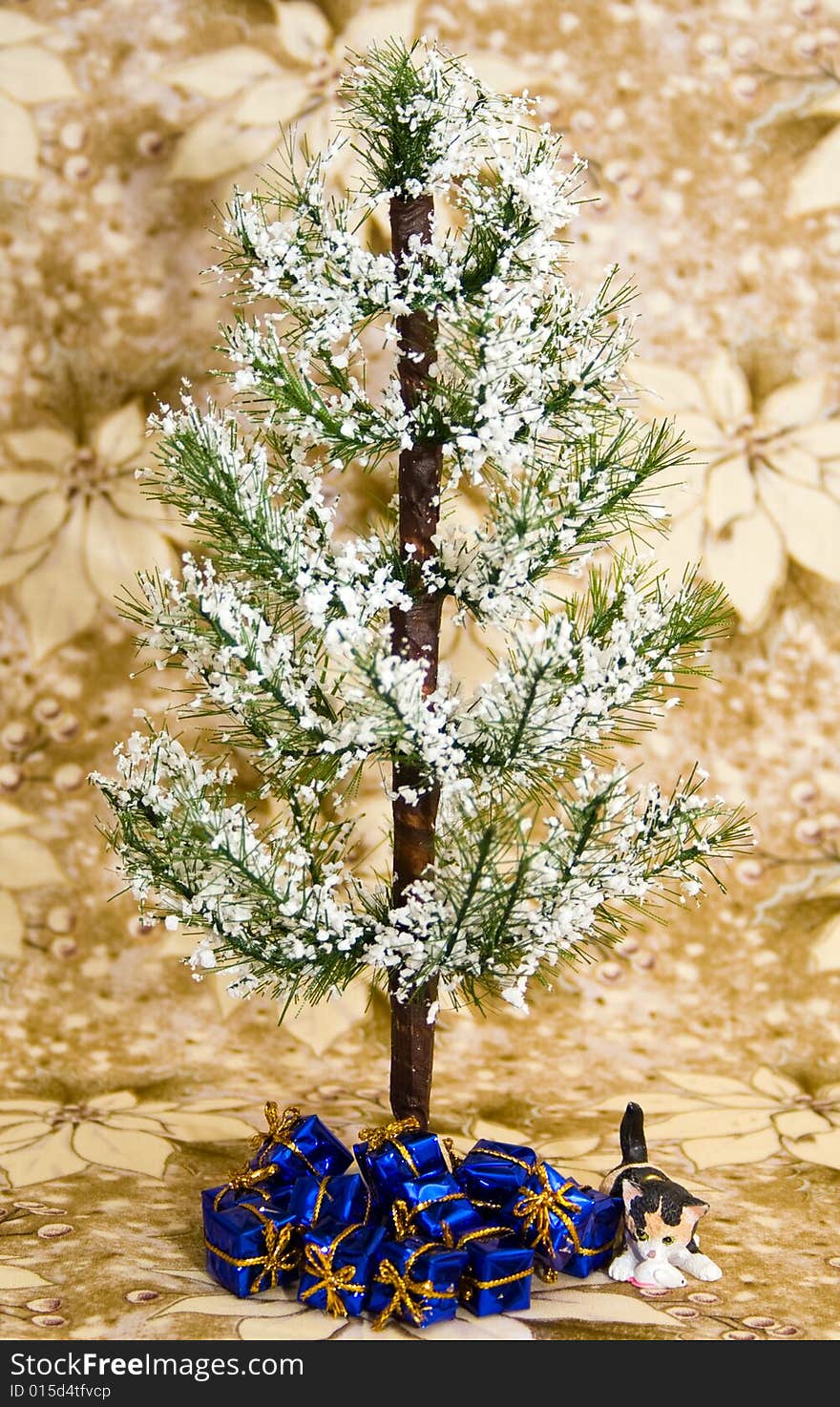 Winter holiday tree with blue presents and a little cat ornament underneath. Background is white / gold poinsettia.